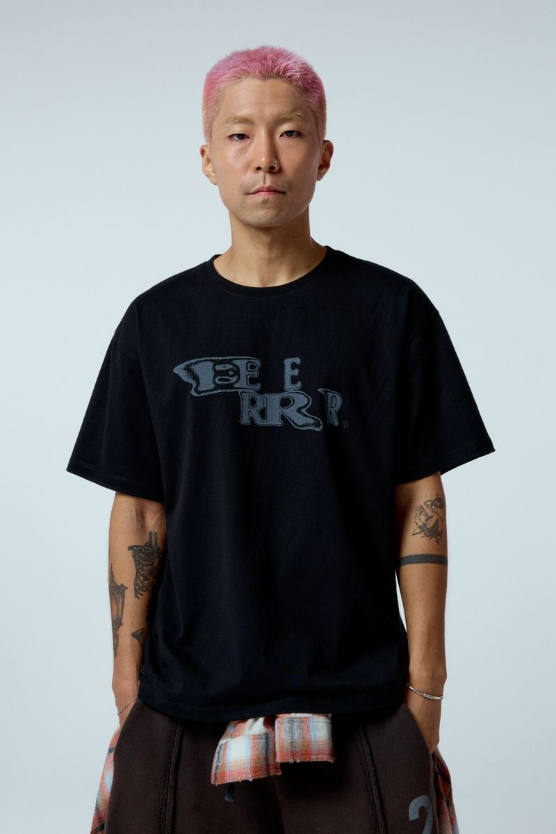 ER(EEERRR)（イーアール）の「EEERRR Distorted ロゴ オーバークロップフィットTシャツ (ブラック)（トップス）」