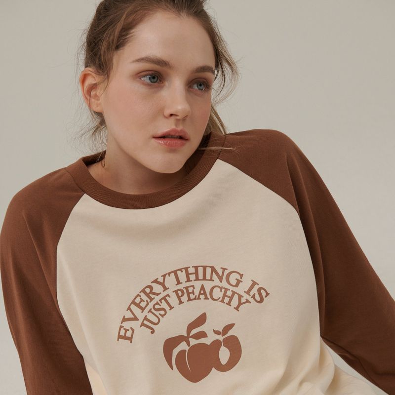 Between A and B（ビットウィーンエーアンドビー）の「PEACH ARCH PRINT RAGLAN LONG SLEEVE T-SHIRT_CHOCOLATE（Tops）」
