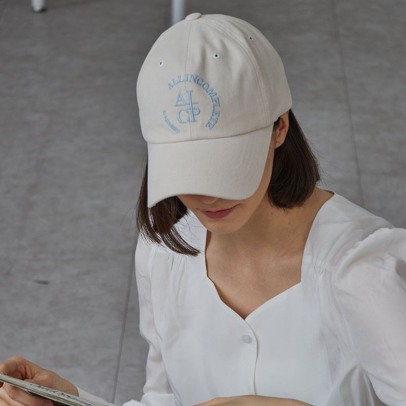 ALLINCOMPLETE（オールインコンプリート）の「ラウンドロゴボールキャップ (Cream Beige)（帽子）」