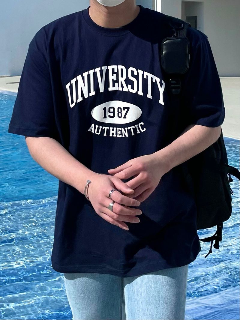 NEVERDOWHY（ネバードゥワイ）の「JR ユニバーシティプリンティングルーズフィットTシャツ（トップス）」