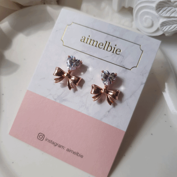 aimelbie（アイメルビー）の「[CHUU Piercing] ハートクリスタル&リボンピアス - ローズゴールド（アクセサリー）」