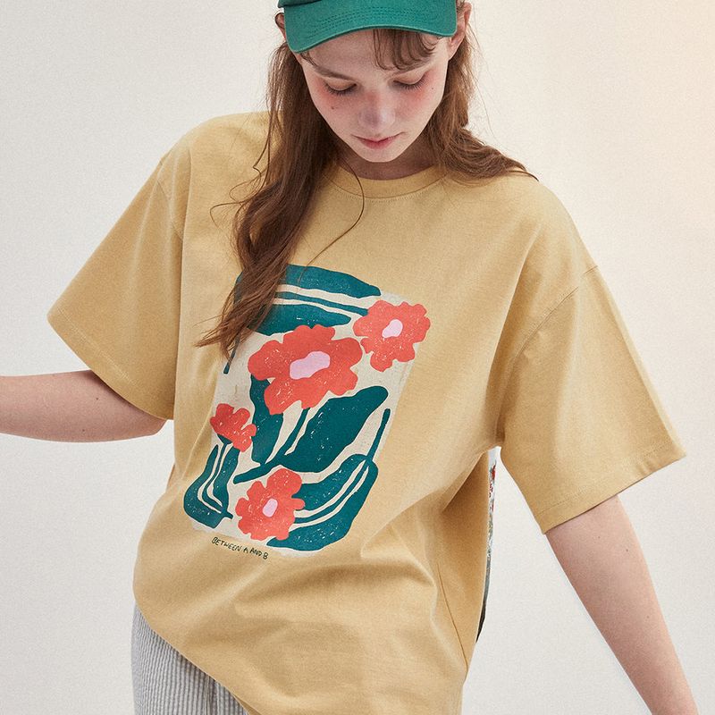 Between A and B（ビットウィーンエーアンドビー）の「花の絵 オーバーサイズTシャツ イエロー（トップス）」