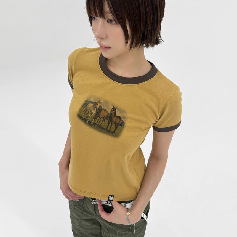 UNSTEADYMARKET（アンステディマーケット）の「ホース グラフィック Tシャツ_マスタード（トップス）」