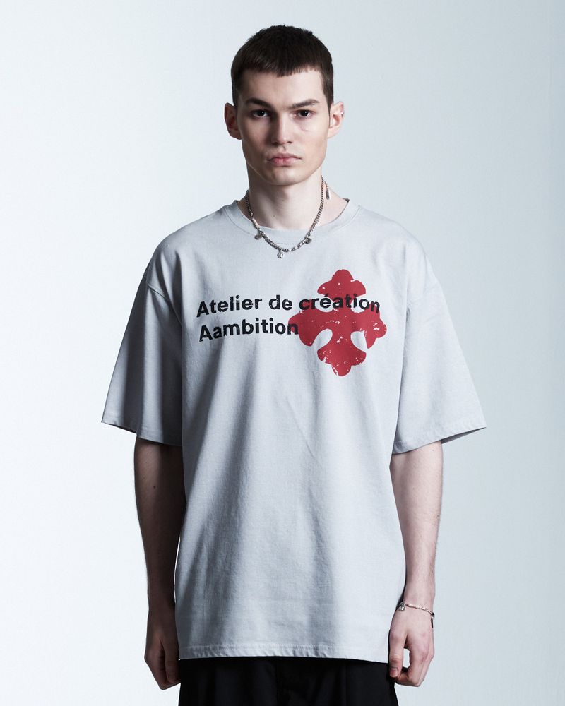 AAMBITION（アアンビション）の「Atelier Cross T-shirt (Melange-White)（Tops）」