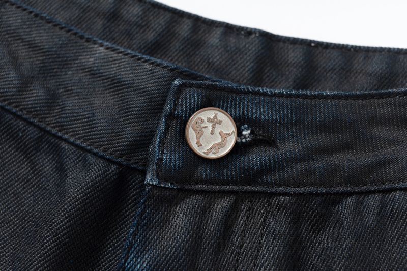 COATED KNIFE-SCRAPED HAND-WIPED DISTRESSED BOOTCUT JEANS
